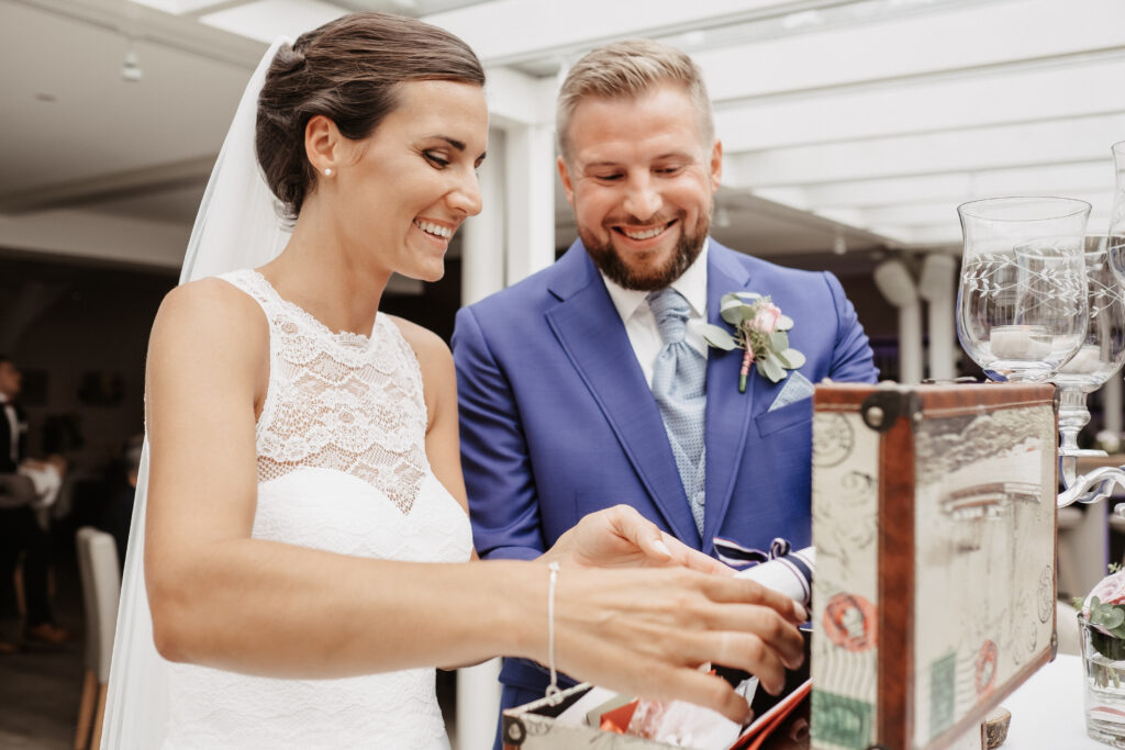 Hochzeitspaar legt Briefe in einen Koffer - Trauritual
